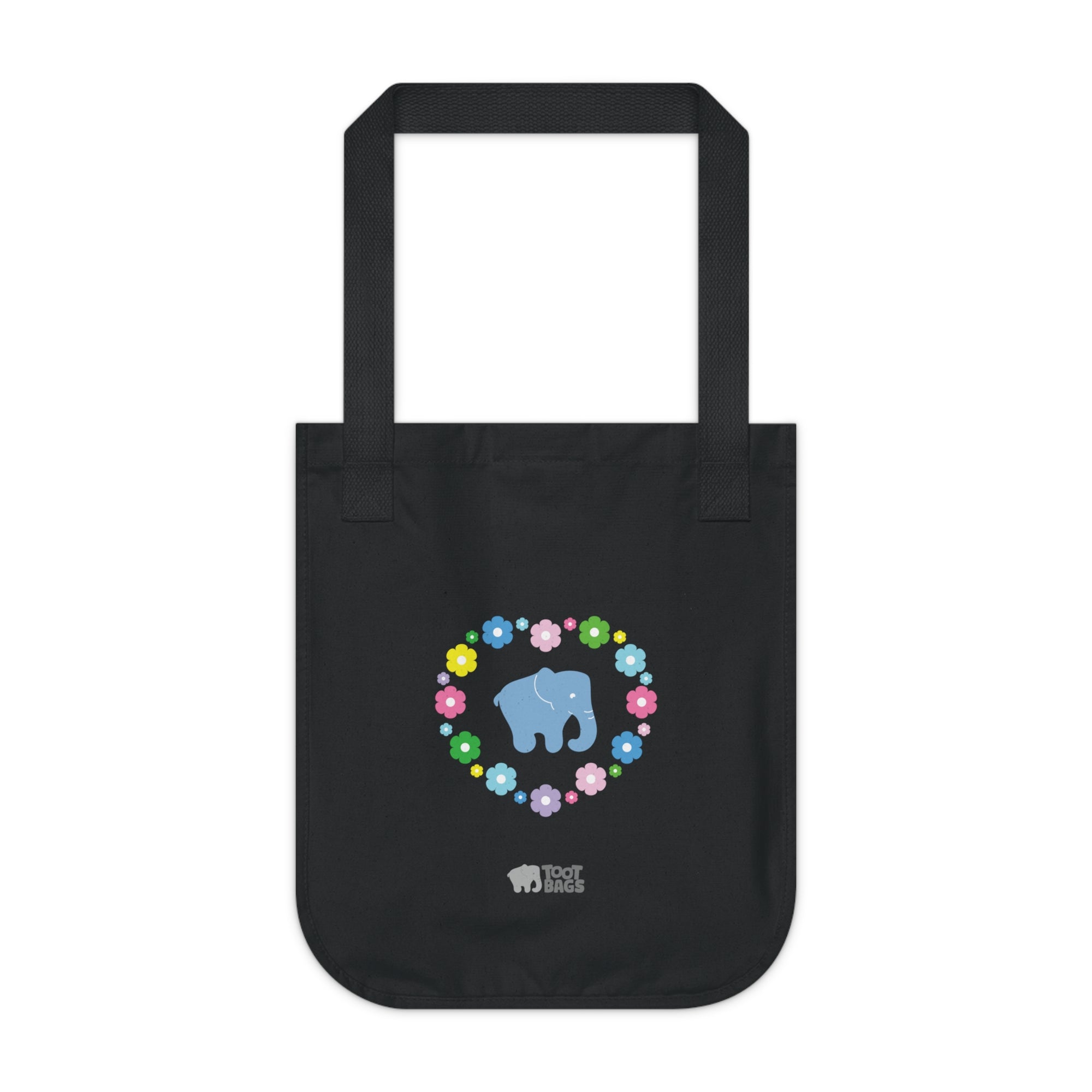 Black canvas tote bag featuring a colorful printed design; a blue elephant with floral heart shaped design on a white background.  