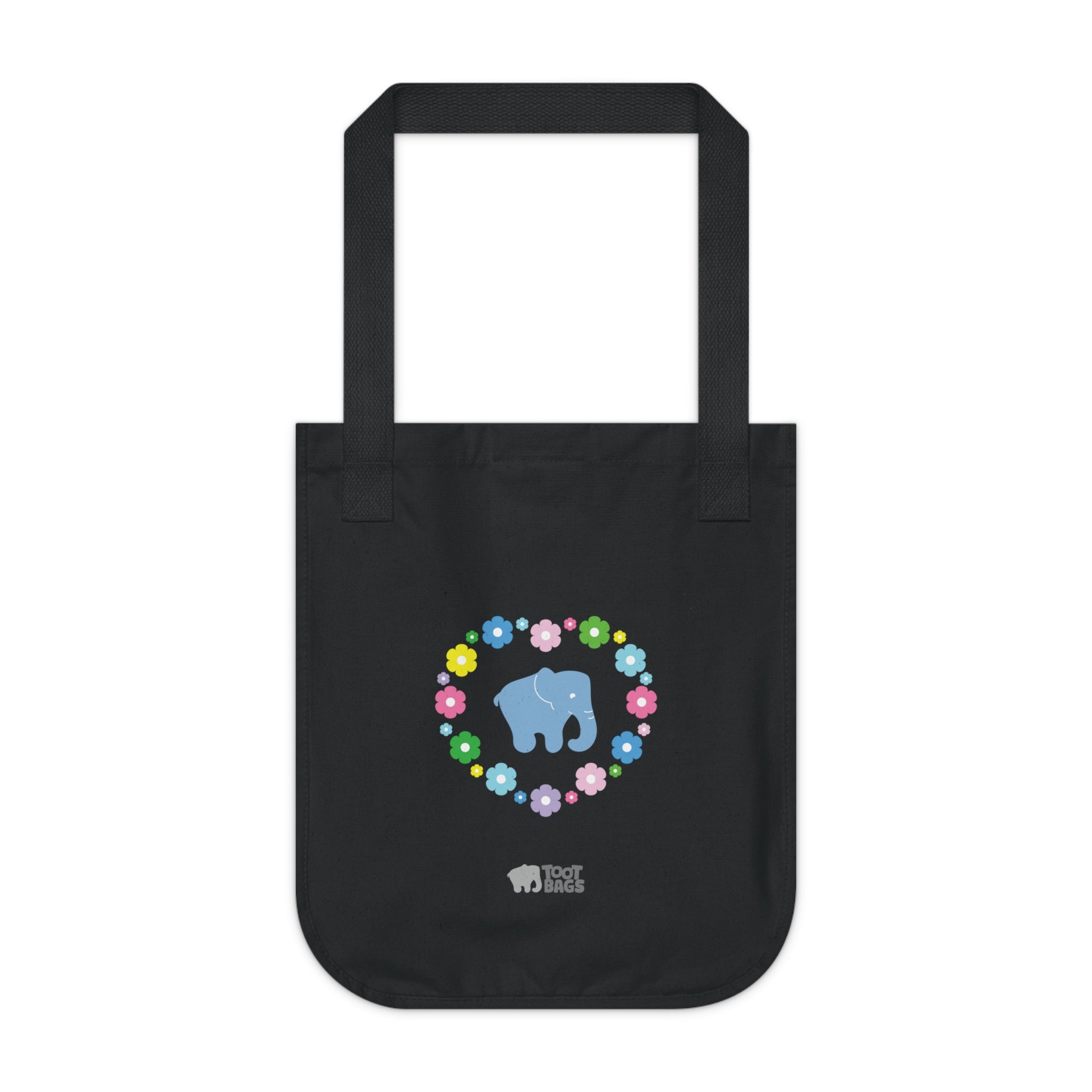 Black canvas tote bag featuring a colorful printed design; a blue elephant with floral heart shaped design on a white background.  
