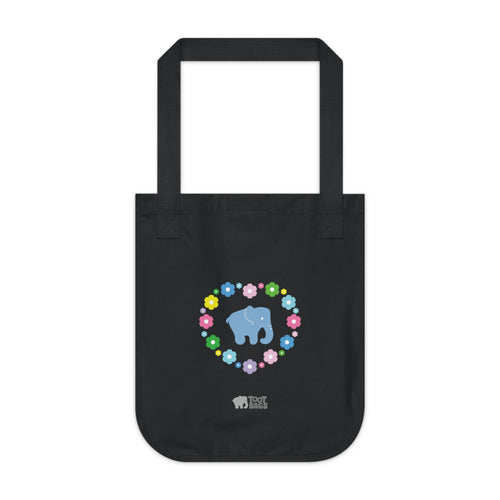 Black canvas tote bag featuring a colorful printed design; a blue elephant with floral heart shaped design on a white background.  