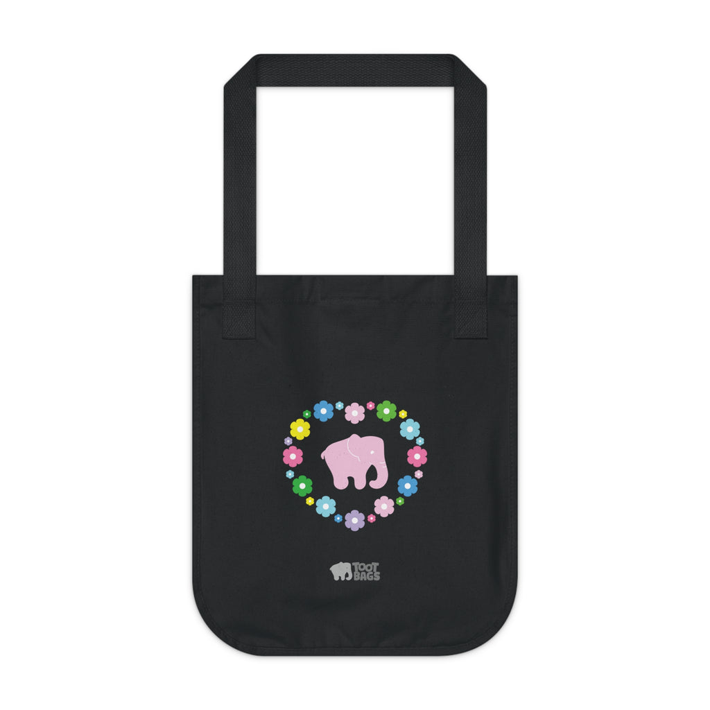 Black canvas tote bag with a printed heart design featuring a pink elephant and colorful flowers on a white background.
