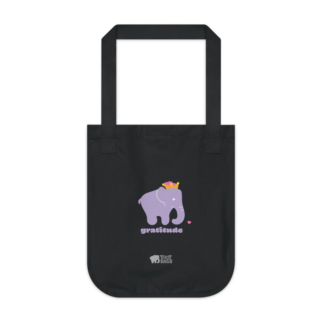 Black canvas tote bag featuring a printed design; a purple elephant, purple 'gratitude' text and colorful hearts on a white background.