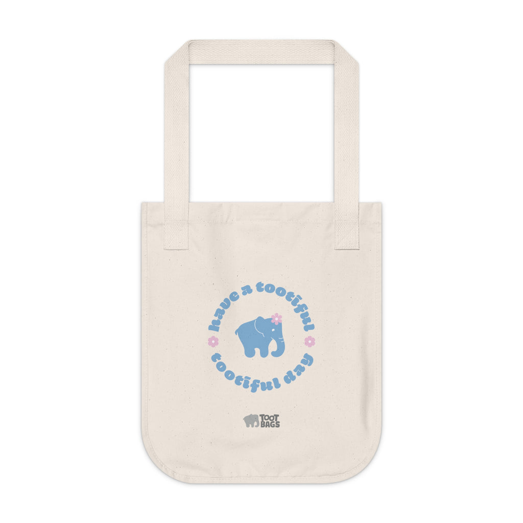 Natural beige canvas tote bag with a printed design featuring a blue elephant and 'have a tootiful tootiful day’ text with pink floral design on a white background.