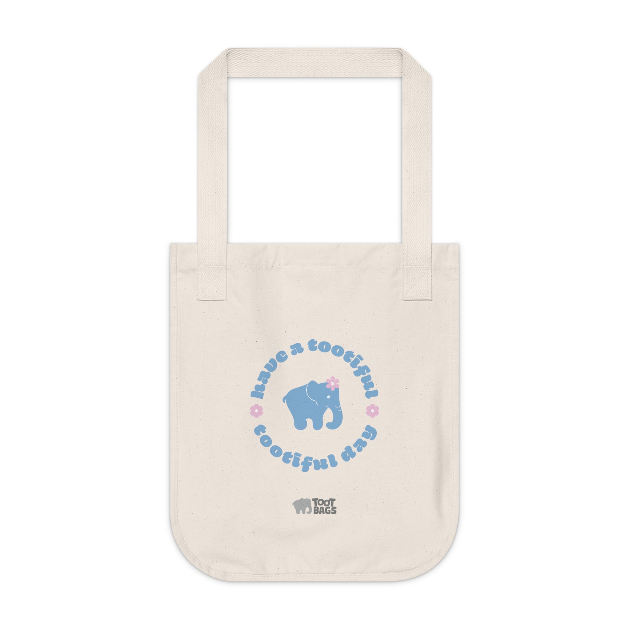 Natural beige canvas tote bag with a printed design featuring a blue elephant and 'have a tootiful tootiful day’ text with pink floral design on a white background.