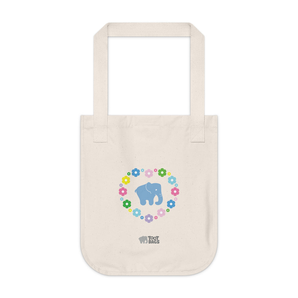 Natural beige canvas tote bag featuring a colorful printed design; a blue elephant with floral heart shaped design on a white background.  