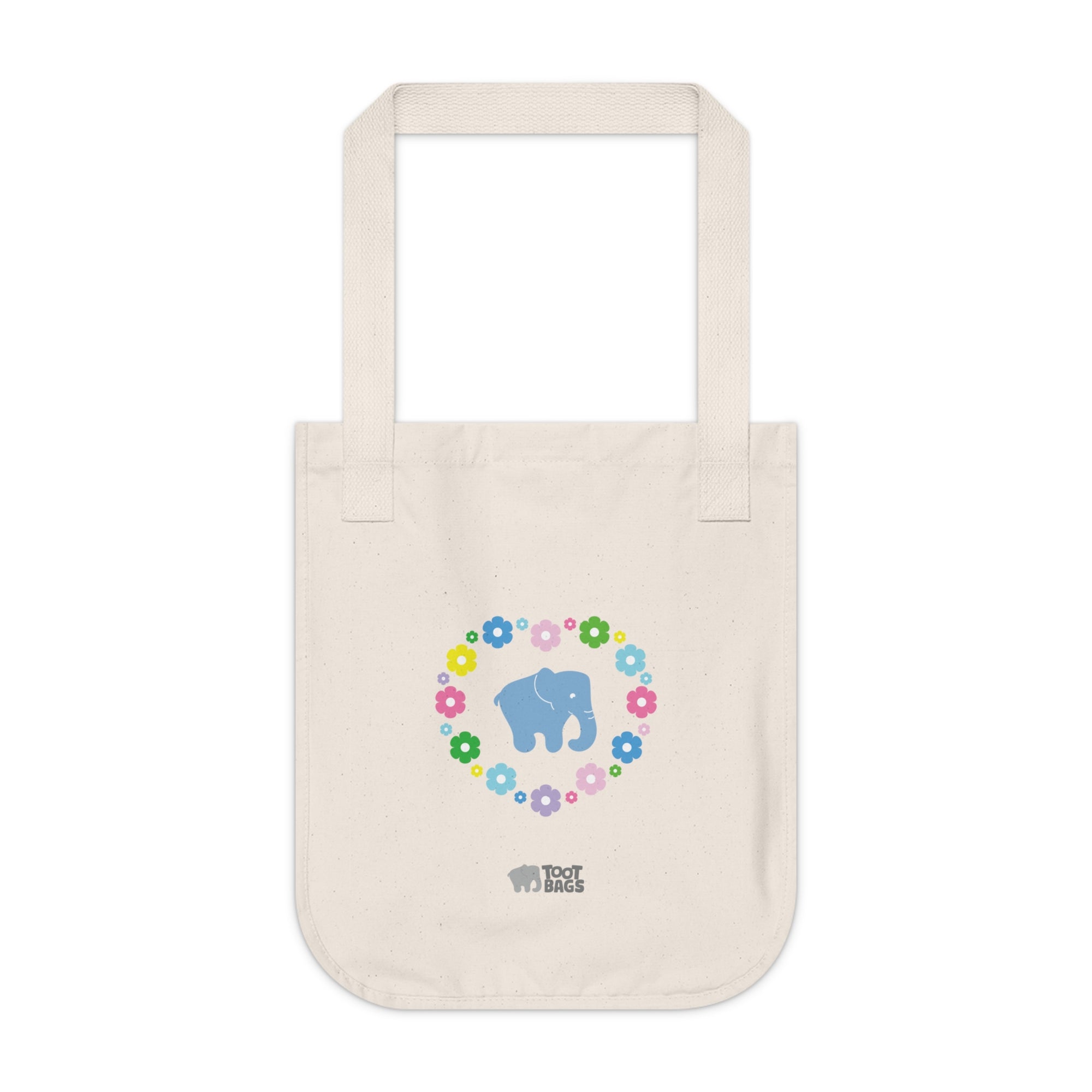 Natural beige canvas tote bag featuring a colorful printed design; a blue elephant with floral heart shaped design on a white background.  
