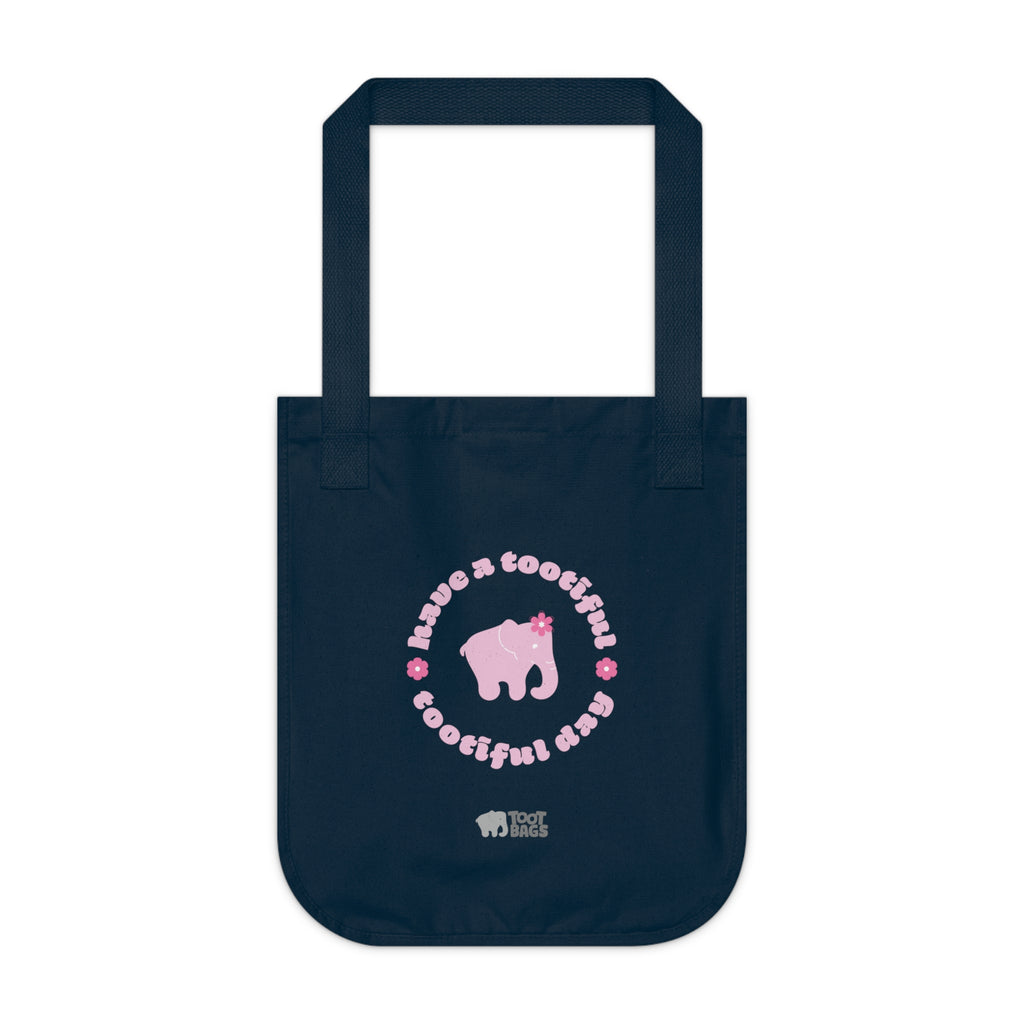 Navy blue canvas tote bag with printed design featuring a pink elephant, 'have a tootiful tootiful day’ text with colorful pink flowers on a white background.